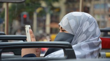 Muslim woman using her iphone