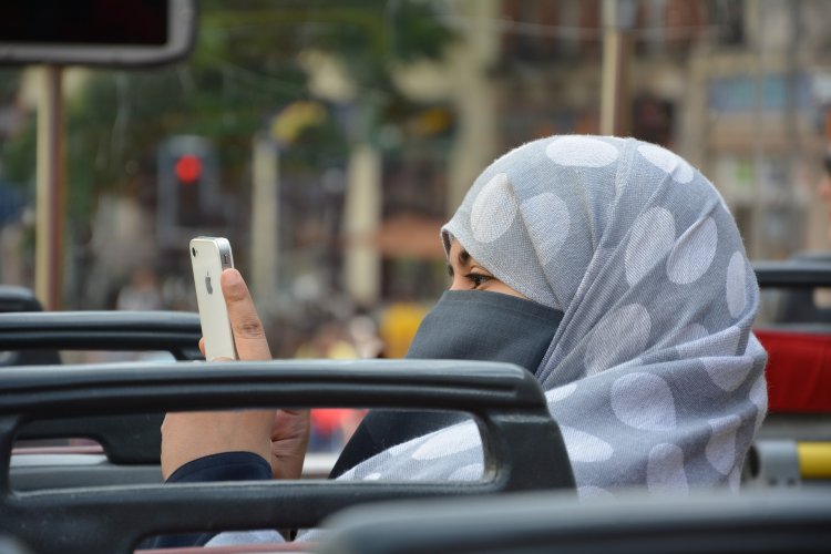 Muslim woman using her iphone