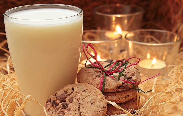 Glass of milk with cookies & candles